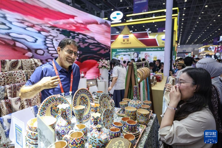 第6回中国国際消費品博覧会で、イランの製品についての紹介に耳を傾ける来場者（4月16日撮影・張麗芸）。