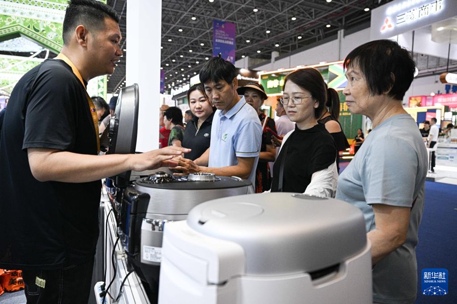 第6回中国国際消費品博覧会で、韓国ブランドの炊飯器を来場者に紹介する出展者（4月16日撮影・蒲暁旭）。