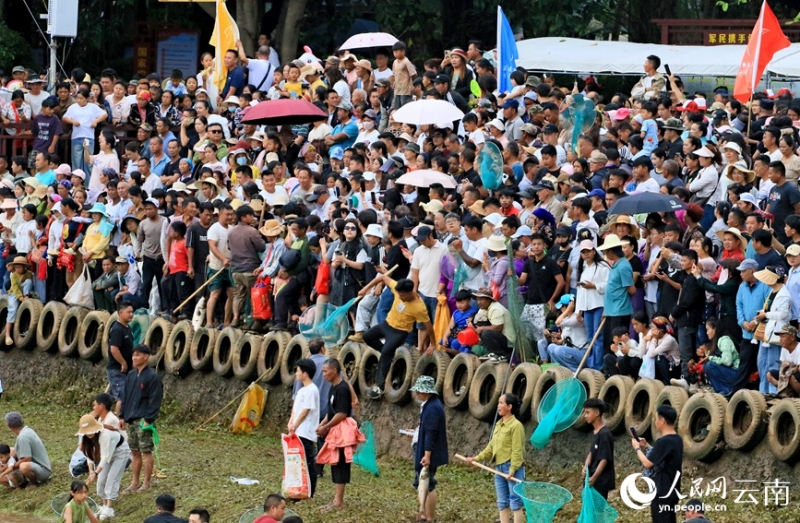 「神魚」のつかみ取りイベントの様子を川辺で眺める多くの市民や観光客（5月3日撮影・陳永剛）。