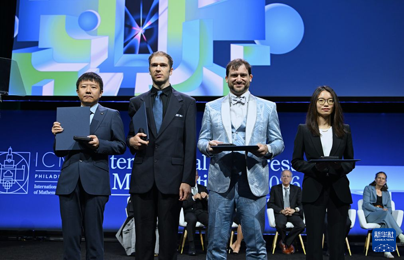 2026年国際数学者会議の開会式で記念撮影する4人のフィールズ賞受賞者。中国の数学者・鄧煜氏（写真一番左）、王虹氏（写真一番右）、米国の数学者ジョン・パードン氏（写真左から2番目）、カナダの数学者ジェイコブ・ツィマーマン氏が受賞（7月23日撮影・李睿）。